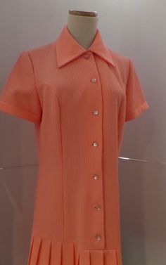 This salmon pink dress is vintage hipster with its dropped waist and accordian pleats. It has a 1920s style with the silhouette. The label is A Yardley Fashion. It is machine washable. Twiggy wore one of Gibbs dresses to her premiere which heightened the popularity of his label. He became perhaps most famous for his extraordinary knitwear designs, undeniably inspired by his Scottish origins. Initially hand machined by Mildred Boulton, who worked from Gibb's designs and Kaffe Fassett's swatches, Retro Pink Collared Dress, Pink Fitted Dress With Accordion Pleats, Fitted Pink Dress With Accordion Pleats, Vintage Pink Collared Dress, Pink Vintage Collared Dress, Retro Pink Dress For Work, Pink Retro Dress For Work, Vintage Pink Dress For Work, Pink Retro Vintage Dress For Formal Occasions