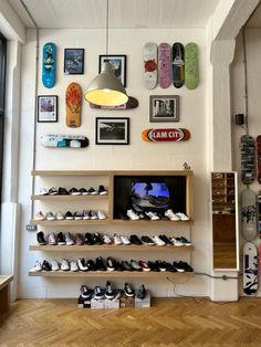 there are many skateboards on the wall in this room, and one is displaying them