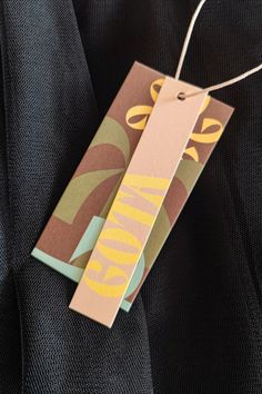 a tag hanging from the back of a black jacket with yellow and green designs on it