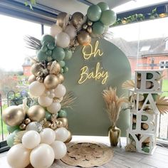 a baby shower is decorated with balloons and greenery