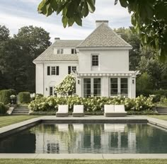 a large white house with a pool in the front yard