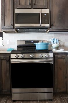 a stove top oven sitting inside of a kitchen next to wooden cupboards and cabinets