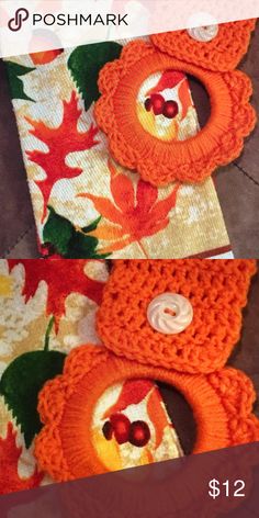 an orange crocheted hat with buttons on the front and bottom, sitting on a floral background