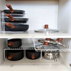 pots and pans are on shelves in the kitchen