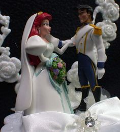 a bride and groom figurine on top of a wedding cake