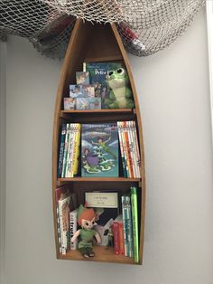 a shelf with books and stuffed animals on it in a room next to a net