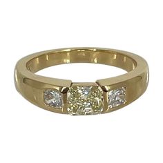 This sleek, bold band is the perfect addition to your stack or makes a statement on its own! This ring features a 0.55 carat fancy light yellow radiant set east-west, following the line of the band. On either side are two white radiant diamonds, F color and VS1 clarity, which total 0.27 carats. Crafted in 18K yellow gold, the band is 4mm wide and has a flat profile so it will stack perfectly with other rings. This versatile piece can be worn on any finger, and is a size 6. Customization and sizi Luxury Yellow Square Cut Rings, Gia Certified Rectangular Gold Diamond Ring, Gia Certified Classic Rectangular Diamond Ring, Classic Gia Certified Rectangular Diamond Ring, Radiant Cut Diamond Ring With Single Cut Diamonds, Yellow Single Cut Diamond Rings For Anniversary, Yellow Rings With Single Cut Diamonds For Anniversary, Yellow Square Cut Ring For Anniversary, Classic Gia Certified Square Cut Diamond Ring