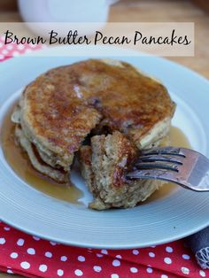 a white plate topped with pancakes covered in syrup