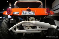 the back end of an orange and white truck with its license plate on it's bumper