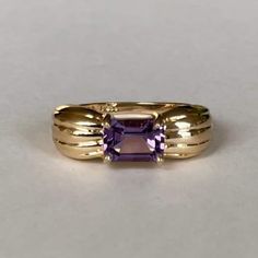 Mid Century 14K Emerald Cut Amethyst, Size 5.25, 2.3 grams, February Birthstone  Size: 5.25 Weight: 2.3grams Main Stone: Amethyst (1 stone) Size Stone: ca. 6.88mm x 4.88mm  Cut: Emerald Color: Beautiful Medium Dark Purple Marking: 10K, PINA? Band Material: 10 Karat Solid Gold Tested: Olympus Vanta GX Precious Metal Analyzer, Presidium Gemtester ll- tested Amethyst (testing performed by 3rd party) Condition: Excellent preowned- very light wear out throughout - Refer to picture for condition. All Emerald Color, 3rd Party, February Birthstone, February Birth Stone, Precious Metal, Dark Purple, Emerald Cut, Rings Statement, Precious Metals