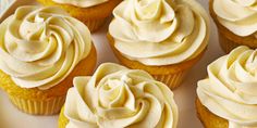 cupcakes with white frosting sitting on a plate