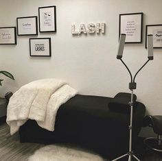 a black couch with a white blanket on top of it and some pictures above it