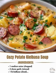 a bowl of soup with sausage, potatoes and parsley in it on a table