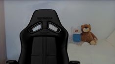 a black office chair sitting next to a teddy bear