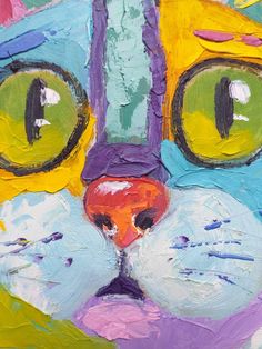 a painting of a cat's face with green eyes and yellow nose is shown