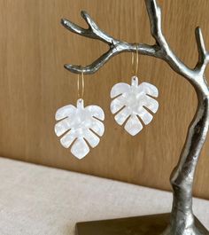 White monstera leaf earrings, featuring tropical leaf designs paired with elegant gold hoops. These geometric earrings bring a boho-chic flair to any outfit, making them a stylish and lightweight accessory for daily wear or special occasions. Ideal as a gift for her, these earrings add a touch of nature-inspired elegance. White Monstera, Leaf Earrings Gold, Monstera Leaf Earrings, Outfit Boho, Earrings Gold Hoop, Leaf Designs, Earrings Resin, Earrings Geometric, Tropical Leaf