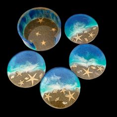 four glass buttons with stars on them in the shape of a sun and ocean scene