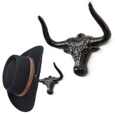 an oxen head and hat hang on a white wall