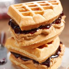 three waffles stacked on top of each other with jelly and syrup in them