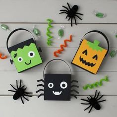 three halloween treat bags with faces and spideres on them, all decorated in black and green