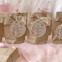 small brown paper bags with floral designs on them sitting on a pink cloth covered table