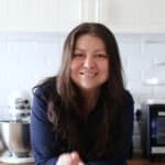 a woman sitting at a kitchen counter smiling for the camera