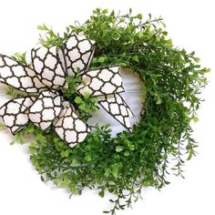 a green wreath with white and black decorations