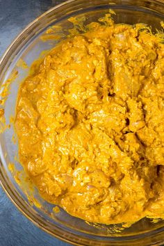 a glass bowl filled with yellow food on top of a table