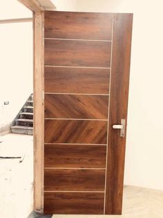 a wooden door in the middle of a room with stairs leading up to an entrance