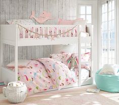 a white bunk bed sitting next to a window in a room with pink and green decor