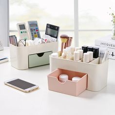 an office desk with various items on it and a cell phone next to the pen holder