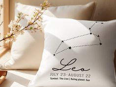 a pillow with the name leo on it next to some pillows and a vase filled with flowers