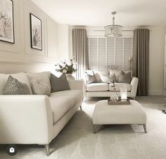 a living room filled with white furniture and lots of window treatments on the windowsill