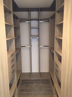 an empty walk in closet with wooden shelves