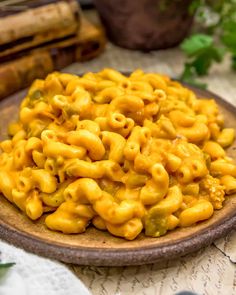 a plate full of macaroni and cheese on a table next to some books