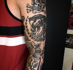 a man with a skull and flowers tattoo on his arm