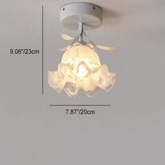 a white ceiling light with flowers on it and measurements for the bulb area in front