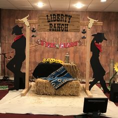 a stage set up with hay bales and cowboy decorations