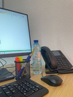 a computer monitor, keyboard and mouse on a desk