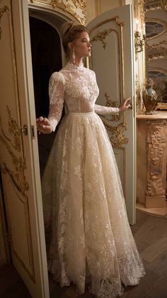 a woman in a wedding dress is standing by the door with her hands on her hips