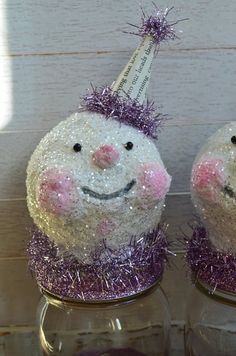 two salt and pepper shakers decorated to look like pigs with purple tinsel on their heads