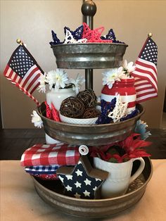 an american patriotic centerpiece is displayed in a bowl on a table with red, white and blue decorations