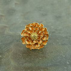 Our stunning Marigold flower brooch add a touch of cheer to any outfit or make a fabulous Mothers' gift for a flower lover. Each brooch is hand finished with orange enamel petals. This beautiful brooch embodies nature with its intricate realistic design and attention to detail. Designed by us, at our London office. The marigold is a symbol of happiness, joy, optimism and good luck. Marigolds are the birth month of October and perfect for any occasion. Size: (L) 29mm x (W) 29mm Metal colour: Gold tone Brooch fitting: Pin with safety catch Each item is presented on a recycled paper gift card (as shown), packed in a biodegradable bag and then placed in an eco-friendly envelope (also shown). Orders are sent in 100% recyclable paper padded envelopes, to keep the jewellery safe during delivery. Marigold Jewelry, Luck Flower, Marigold Orange, Blue Bell Flowers, London Office, Marigold Flower, White Jewelry Box, Jewelry Safe, Orange Flower