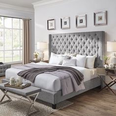 a large bed sitting in a bedroom on top of a hard wood floor next to a window