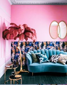 a blue couch sitting next to a pink wall