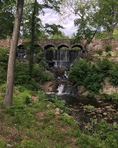 an old stone bridge over a small waterfall