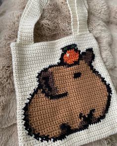 a crocheted bag with an image of a beaver on it's side