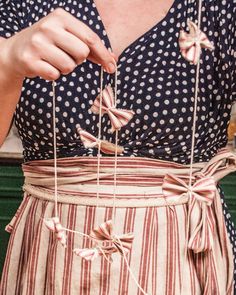 a woman is holding some string with bows on it