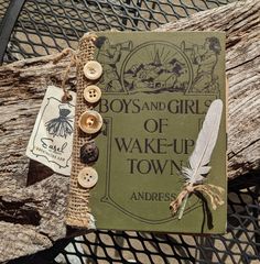 a book with buttons on it sitting on top of a wooden table next to a wire fence