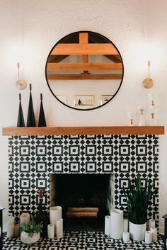 the fireplace is decorated with black and white tiles